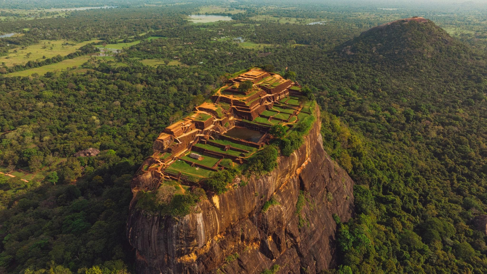 Sigiriya rock fortress rising above green forest